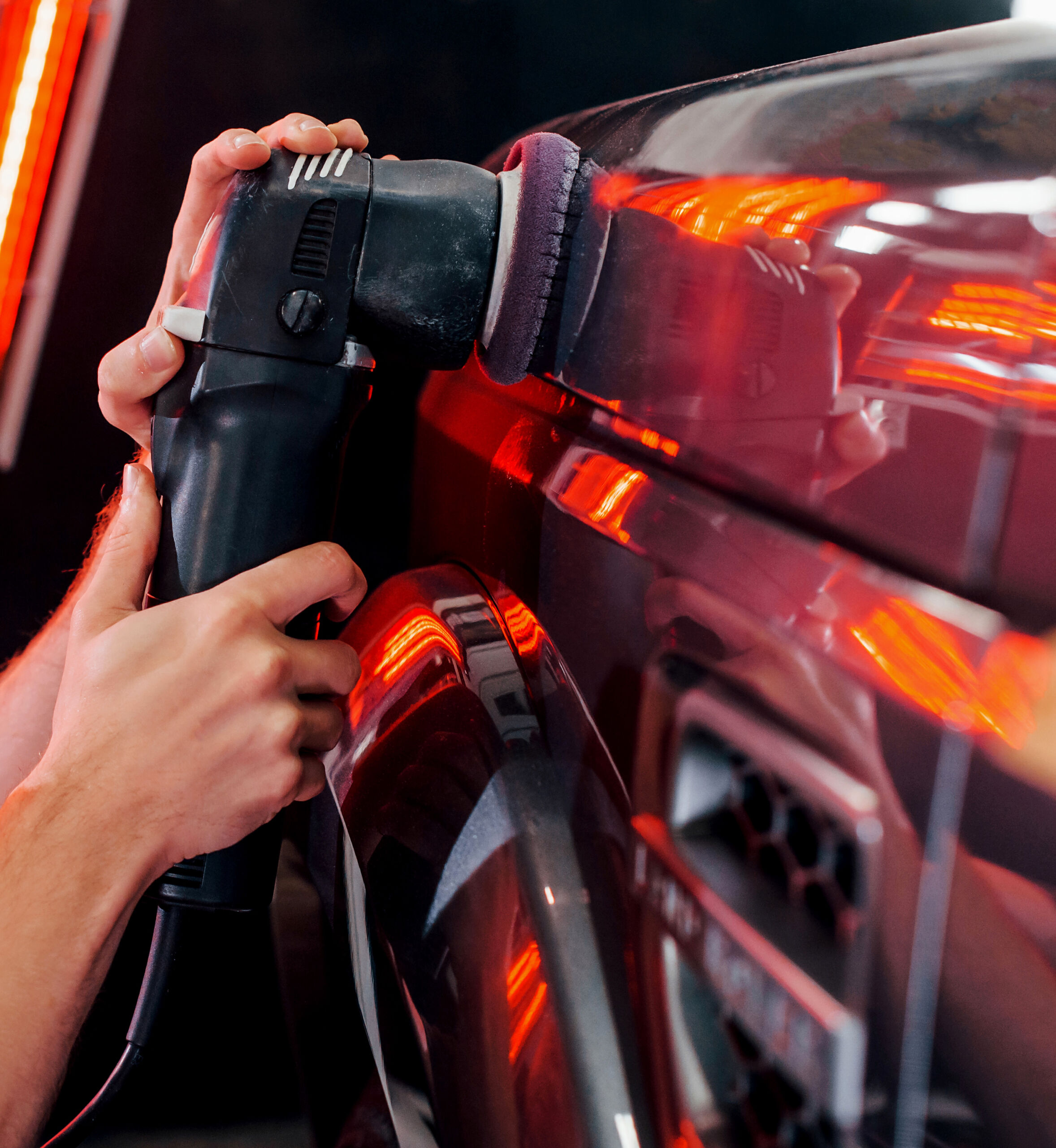 Guy polishing surface of vehicle. Modern black automobile get cleaned by man inside of car wash station Guy polishing surface of vehicle. Modern black automobile get cleaned by man inside of car wash station.
